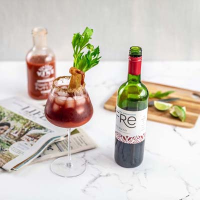 Color image of a bottle of FRE Alcohol-Removed Red Blend next to a red cocktail with celery and bacon garnish