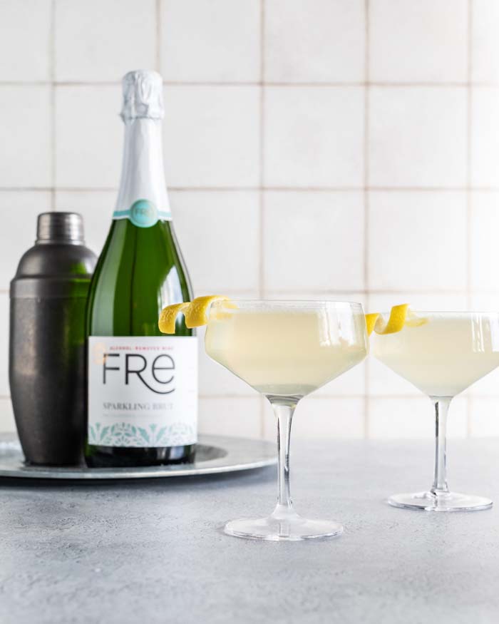 color image of a bottle of FRE Alcohol-Removed Sparkling Brut with 2 cocktails with a lemon twist as a garnish
