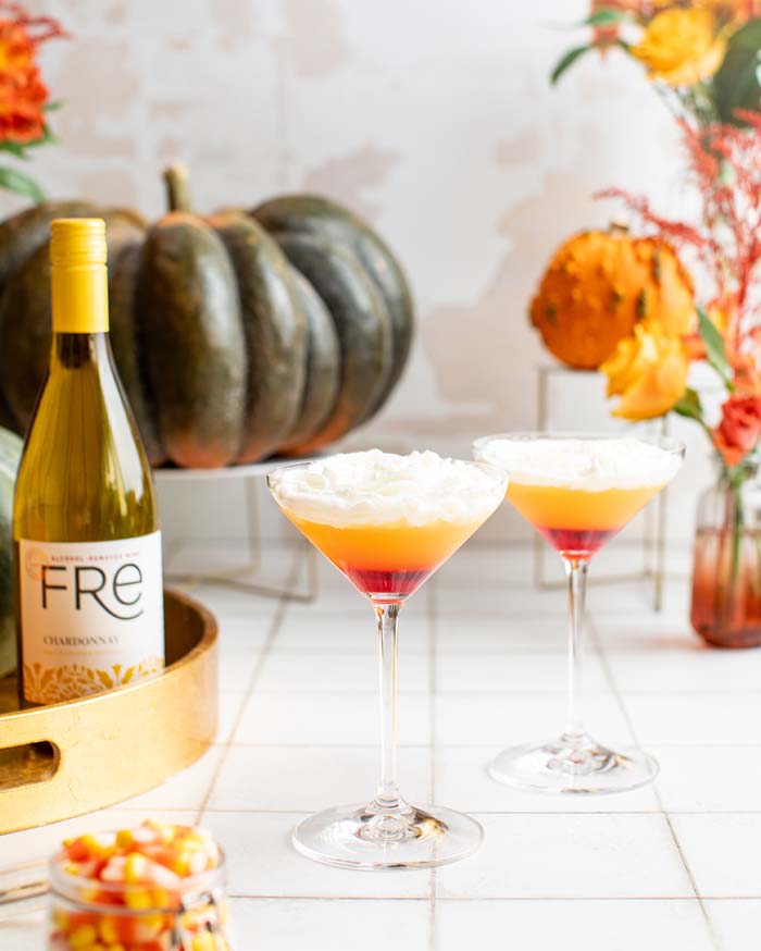 color image of a bottle of FRE Alcohol-Removed Chardonnay with 2 cocktails resembling candy corn