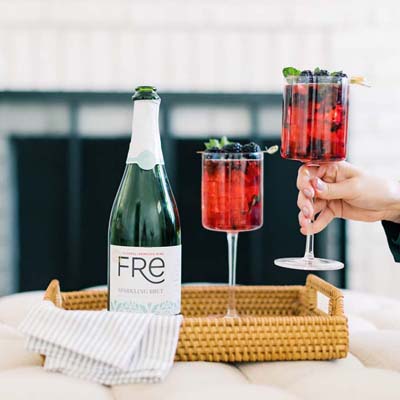 Color image of a bottle of FRE Alcohol-Removed Sparkling Brut with 2 red cocktails