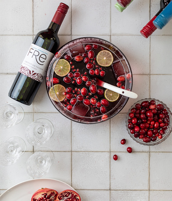 color image of a bottle of FRE Alcohol-Removed Cabernet Sauvignon with a punch bowl filled with wine, cranberries, and lime slices