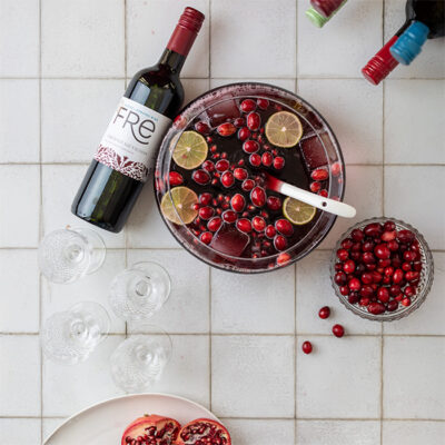 color image of a bottle of FRE Alcohol-Removed Cabernet Sauvignon with a punch bowl filled with wine, cranberries, and lime slices