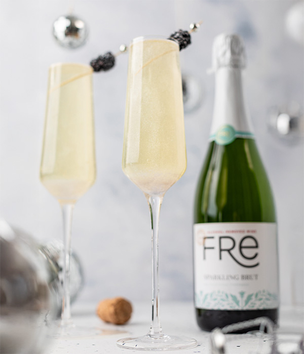 color image of FRE Alcohol-Removed Sparkling Brut with two champagne glasses on a white background