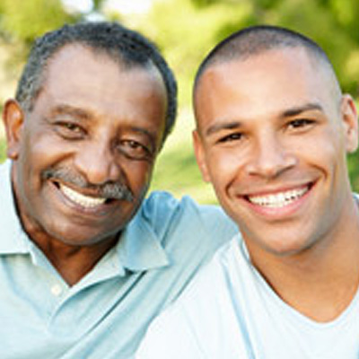 An older man and a younger man smile at the camera