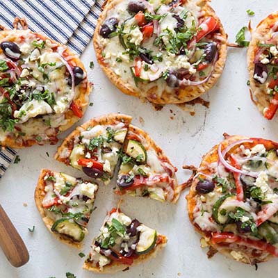 Bird's eye view of some small vegetable and cheese topped pizzas